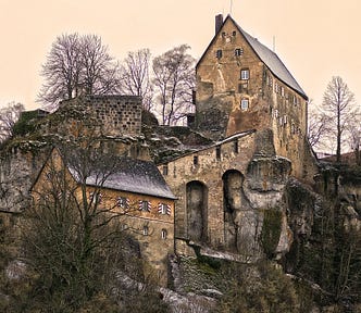 The ruins of a castle on a hill.