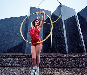 The Hula Hoop Method For Writers. Woman in red dress doing hula hoop.