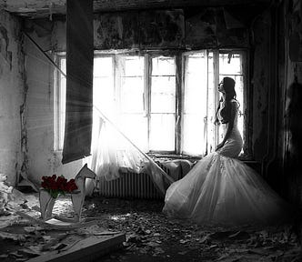 Photo of a woman wearing a wedding dress inside an abandoned house