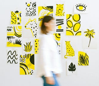 Woman Walking Against Wall With Several Art Sketches
