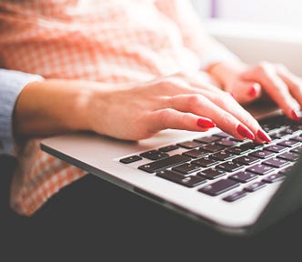 Picture of a woman’s hands typing on a laptop