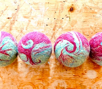 Four felted balls representing dominance/partnership, scarcity/abundace