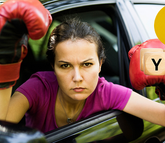 Angry woman in a car with boxing gloves.