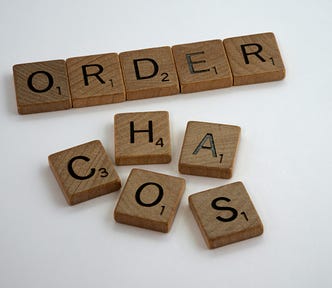Scrabble tiles that spell out the words “ORDER” and “CHAOS”