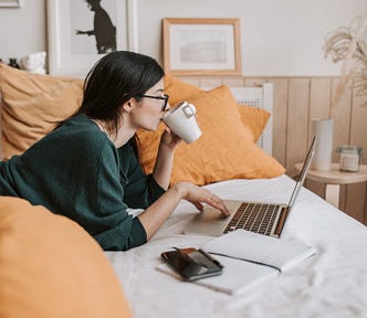 Woman sipping tea as she does a free online course to upgrade her content creation skills