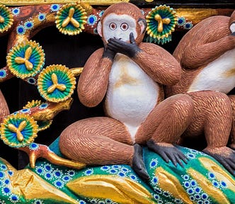 Carving of three monkeys, one covering its ears, one covering its eyes, and one covering its mouth