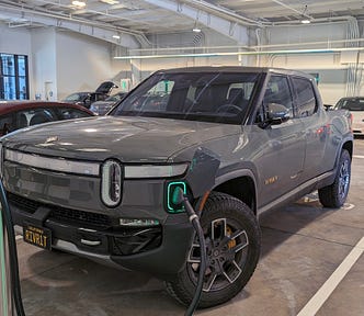 Rivian R1T charging inside of EA’s latest charging concept, a coverted auto garage with many chargers and lougnes