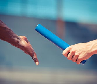 Person handing baton to another during race