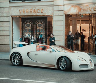 A young rich kid in a supercar in front of a Versace store