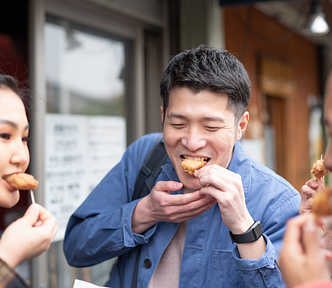 three people eating street food