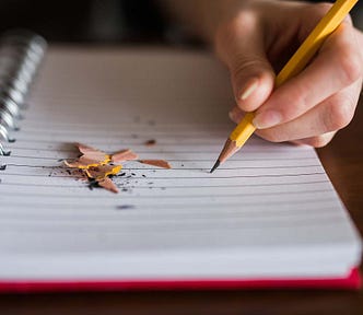 Left-handed person writing with a pencil