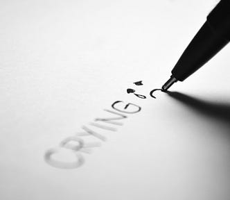 Photo of bold text written in pen — CRYING — followed by a teary face emoji