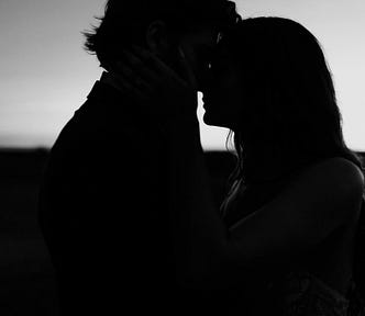 Silhouette of a couple sharing a kiss at sunset, symbolizing emotional connection, presence, and intimacy.