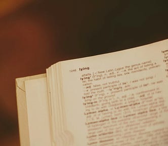 A dictionary page, with the definition of ‘lying’ in focus.