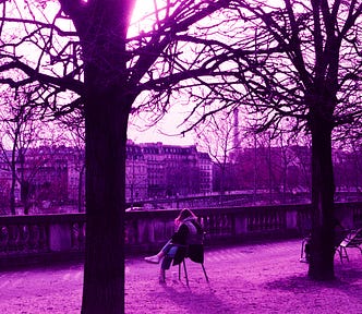 A woman takes in a view of Paris from an elevated position in the Jardin des Tuileries.