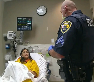 Police talking to a woman in a hospital bed