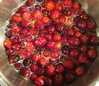 Bright red cranberries, in the process of being made into cranberry sauce.