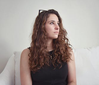 Image of a young woman solemnly looking into space