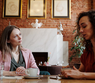 Two women talking over coffee at a restaurant