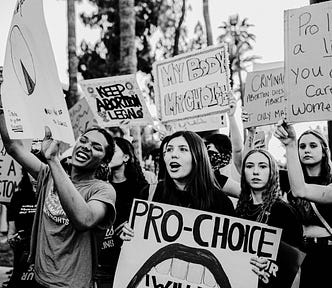 Black and white photograph of women protesting and holding up pro-choice placards.