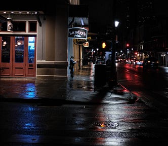 A lady standing in the early morning rain in New Orleans.
