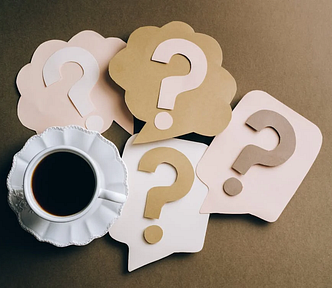 Question marks around a cup of coffe