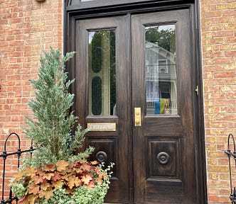 Doorway of brick home with planter on left