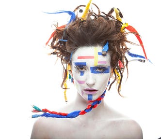 woman in white makeup with wires hanging off her hair and electrical tape on her face — ai vs human intelligent