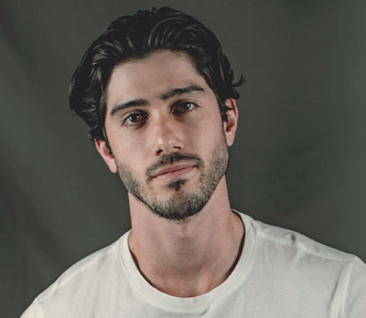 Headshot of man with dark hair and white tee shirt.
