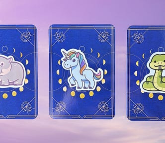 Three oracle card piles with animal stickers on them