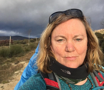 woman in hiking gear with dark skies behind