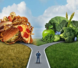 A road fork shows two directions: one represented by junk food and the other represented by green veggies proposed by the weight loss industry.