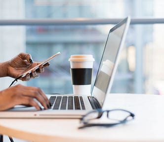 Woman’s hands working on her laptop and phone