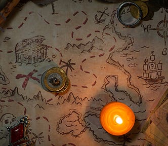 A treasure map, coins, jewels, and a candle.