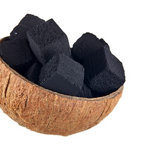 Picture of a coconut bowl filled with charcoal made from coconut leftovers