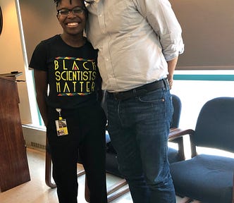 Anicca and Dr. Ward smile at the camera. Standing on the left, Anicca’s  shirt reads “Black Scientists Matter”.