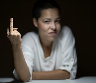 A woman with an angry face and her middle finger extended in a rude gesture.