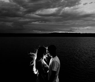 Loving couple silhoutted against a black and white background.