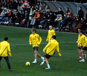 Barcelona players in yellow training tops warming up in a rondo