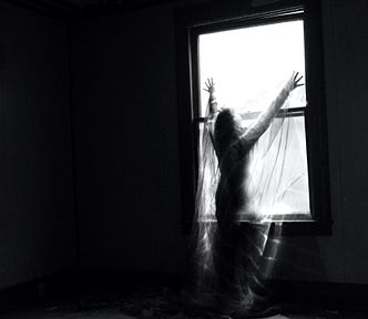 silhouette of woman standing in front of window with arms above her head