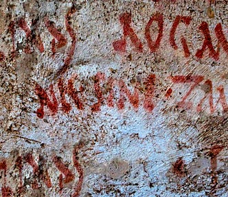 Hand-painted political signage on the walls of ruins in Pompeii