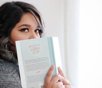 Woman holds book up to her face