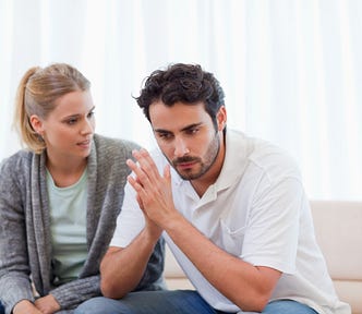 man and woman sitting on couch in deep conversation