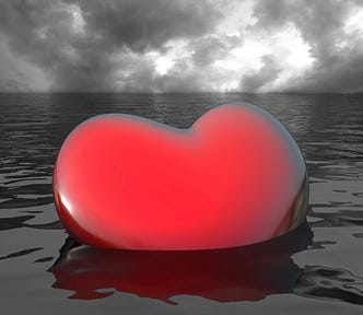 Photo illustration of bright red heart sinking into gray ocean.