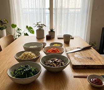 Fresh Bibimbap ingredients arranged in bowls on a sunny home dining table.