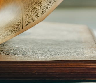 A crisp, close-up photo of a book with one page from the right side in the process of turning.