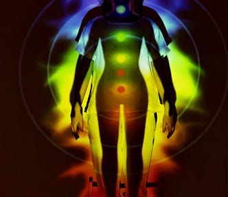 A woman shines with rainbow-colored chakras