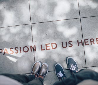 Concrete sidewalk reading “passion led us here”