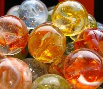 a group of orange, yellow, and blue colored glass marbles