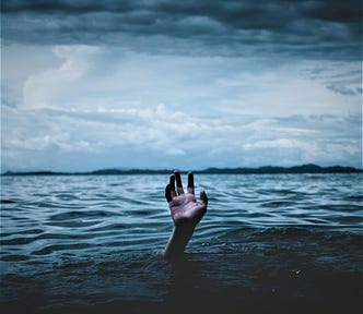 hand coming out of water stormy moody sky